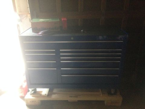 1992 Ford F-150 - A blue toolbox with multiple drawers sits on a wooden pallet, with a green box and red object on top.