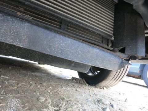 1991 Ford LTD Crown Victoria - Underside view of a car's front bumper and grille, showing the radiator and part of a tire.