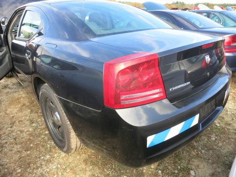 1991 Ford LTD Crown Victoria - Rear view of a black Dodge Charger sedan with a reflective bumper sticker.