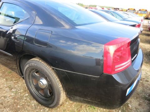 1991 Ford LTD Crown Victoria - A black sedan is parked in a lot with other vehicles and school buses visible in the background.