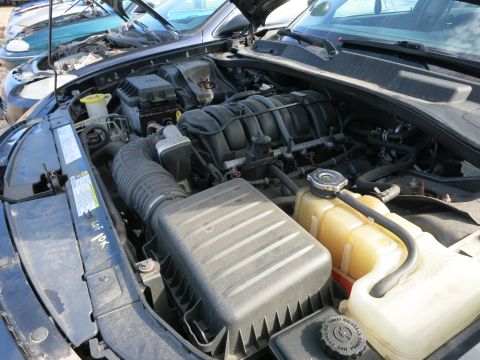 1991 Ford LTD Crown Victoria - The engine bay of a car is visible with the hood open, revealing various engine components.
