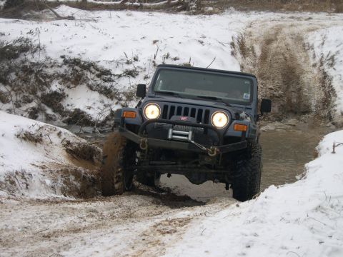 1995 Ford Bronco - This Jeep Wrangler TJ navigates a challenging off-road course covered in snow and mud.