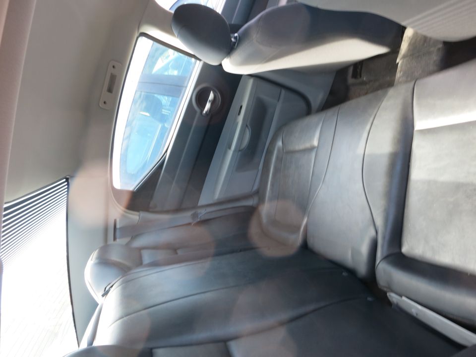Car interior with black leather seats and a window showing a blue sky