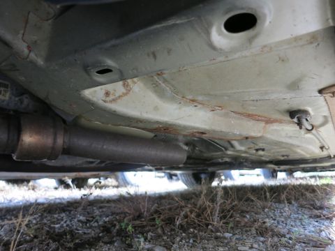 1991 Ford LTD Crown Victoria - Undercarriage of a vehicle, focusing on the exhaust pipe and frame components.