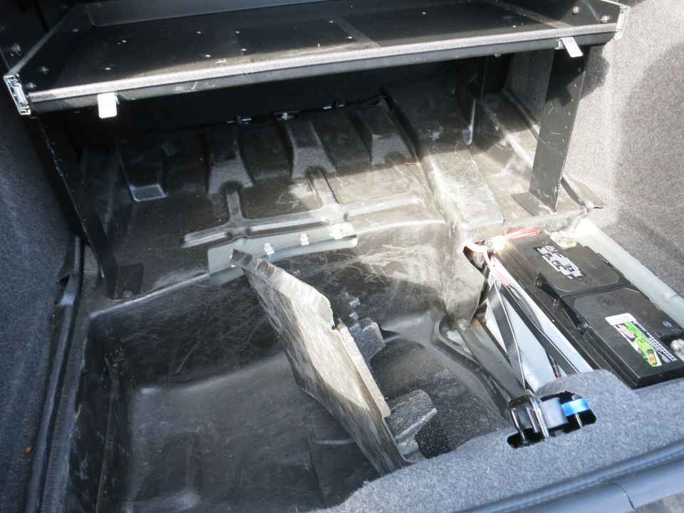Trunk interior showing battery and carpeting