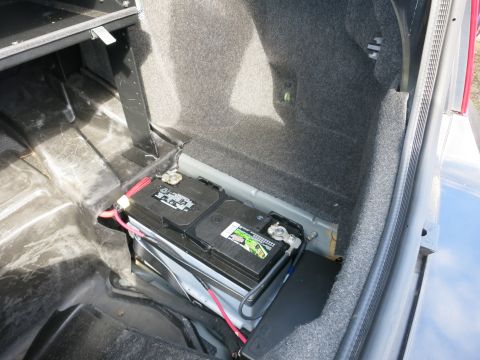 1991 Ford LTD Crown Victoria - Trunk compartment showing a car battery with connected cables.