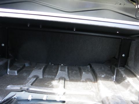 1991 Ford LTD Crown Victoria - The interior of a car's trunk is shown, with a focus on the carpeted rear wall and the textured floor.