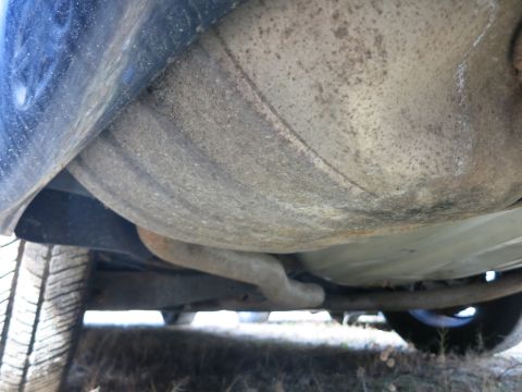 1991 Ford LTD Crown Victoria - The underside of a vehicle, including the exhaust system and fuel tank, is visible from a low angle.