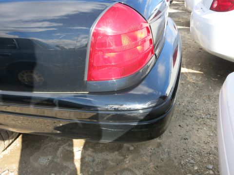 1991 Ford LTD Crown Victoria - Close-up of the rear of a dark Ford Crown Victoria, showing the taillight and bumper.