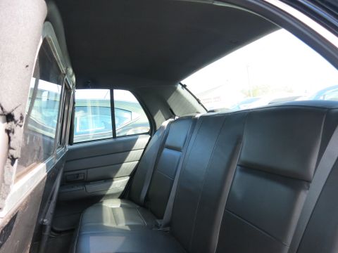 1991 Ford LTD Crown Victoria - The interior of a vehicle shows the rear seats and windows, with another car visible through the glass.