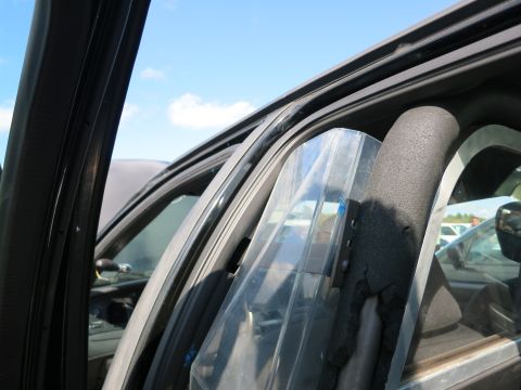 1991 Ford LTD Crown Victoria - The interior of a vehicle shows a clear shield and protective padding installed near the driver's side window.