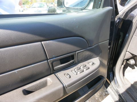 1991 Ford LTD Crown Victoria - View of the driver's side door panel and window controls, with other vehicles visible through the window.