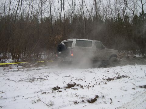 1995 Ford Bronco - A muddy 1992 Ford Bronco struggles in a snowy, wooded area.