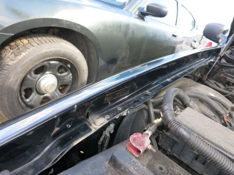 1991 Ford LTD Crown Victoria - A dark police car is parked next to a vehicle with its hood open, revealing the engine components.