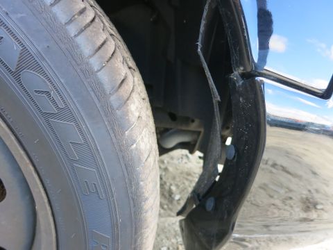 1991 Ford LTD Crown Victoria - A detached fender flare is visible next to the front tire of a vehicle.
