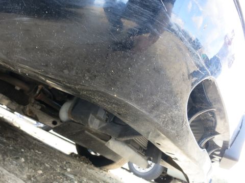 1991 Ford LTD Crown Victoria - Underside view of a black car, revealing suspension and exhaust system details.
