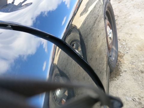 1991 Ford LTD Crown Victoria - Side view of a black car, with reflections of the sky visible on its surface.