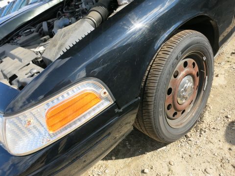 1991 Ford LTD Crown Victoria - Close-up of a 1991 Ford Crown Victoria LTD showing the front fender, headlight, and part of the engine.