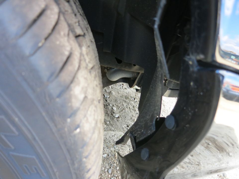 Close-up of a tire and damaged fender liner