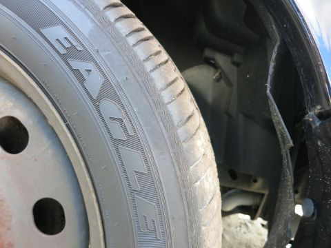 1991 Ford LTD Crown Victoria - A close-up view of a vehicle's tire and the surrounding wheel well area.