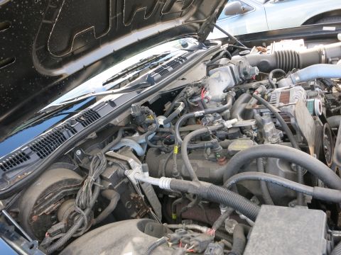 1991 Ford LTD Crown Victoria - The engine bay of a 1991 Ford Crown Victoria LTD is visible, with another vehicle in the background.