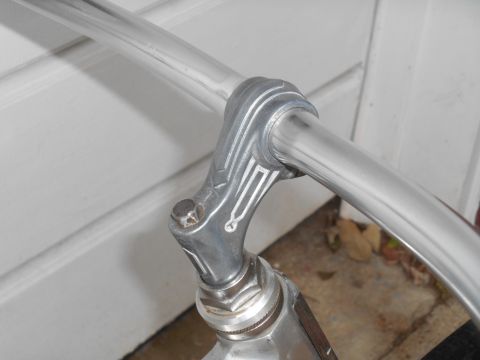 Close-up of chrome bicycle handlebars with decorative metalwork on the stem