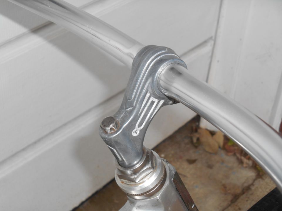 Close-up of chrome bicycle handlebars with decorative metalwork on the stem
