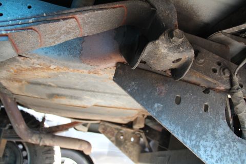 1994 Ford F-250 - The underside of a truck shows significant rust on the frame and exhaust system.