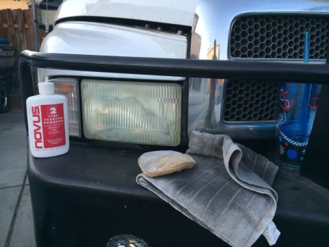 1997 Dodge 3500 - A bottle of Novus scratch remover sits on a truck's bumper next to a rag and a seashell.