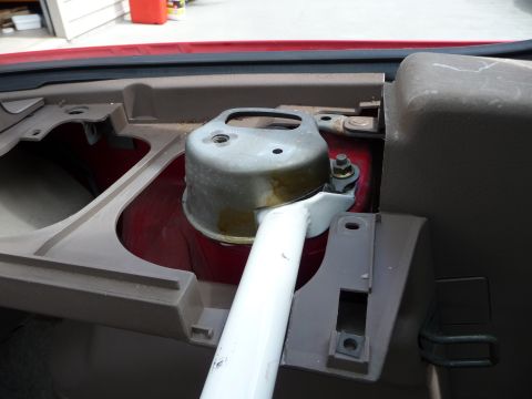 1993 Mazda MX-3 - A white strut brace is visible in the interior of a red vehicle, mounted near the dashboard area.