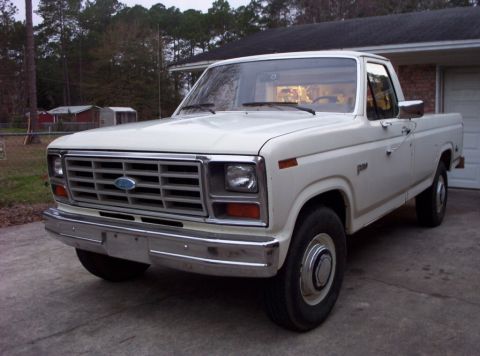 1985 Ford F-250 - This white Ford F-250 pickup truck from the early 1980s is shown in a front 3/4 view.