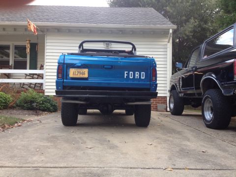 1974 Ford Bronco - Rear view of a blue 1974 Ford Bronco parked next to a black Bronco.
