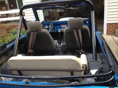 1974 Ford Bronco - Interior view of a blue 1974 Ford Bronco with front and rear seats, roll bar, and dashboard visible.
