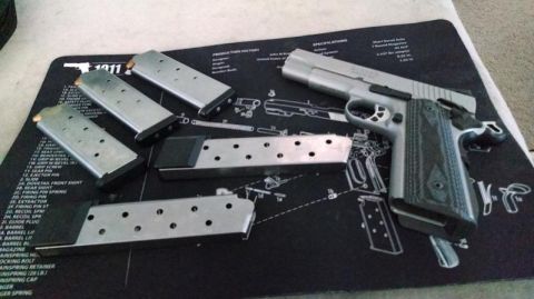 1979 Ford Bronco - A pistol and its magazines are laid out on a diagram mat.