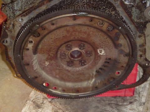 1989 Ford Bronco - Close-up of a rusty engine flywheel with visible bolt holes and gear teeth.