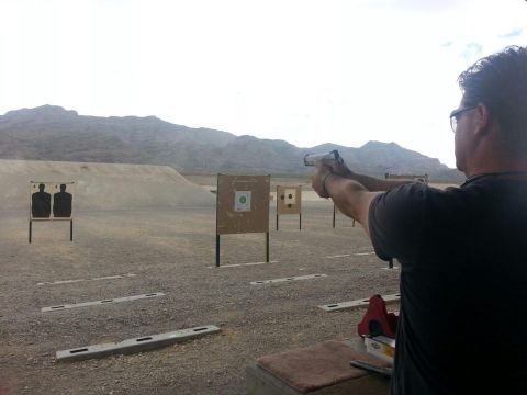 1979 Ford Bronco - A man practices shooting at targets on an outdoor range with mountains in the background. The website SUPERMOTORS.NET is visible in the low…