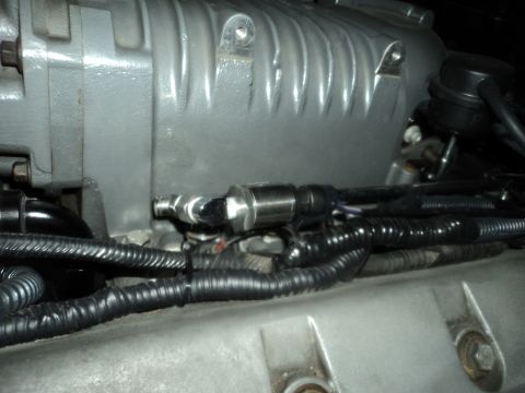 2004 Mercury Grand Marquis - Close-up of an engine component with a sensor and wiring harness, the Supermotors.net logo.