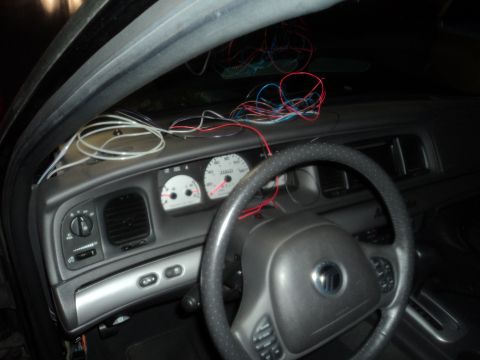 2004 Mercury Grand Marquis - The interior of a 2004 Mercury Grand Marquis displays a dashboard with exposed wiring and a steering wheel.