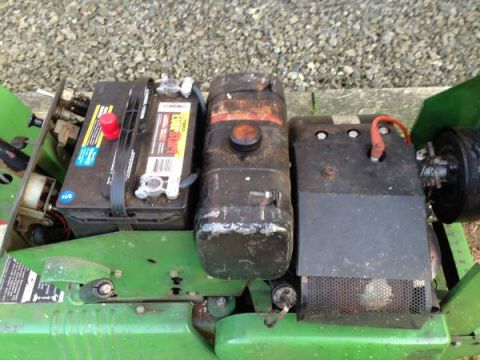 1982 Kubota RTV900 - Close-up view of the engine and battery area of a green utility vehicle.
