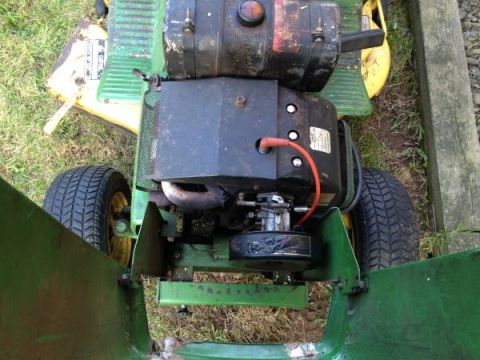 1982 Kubota RTV900 - Top-down view of a green tractor's engine and rear tires, with open green panels on either side.
