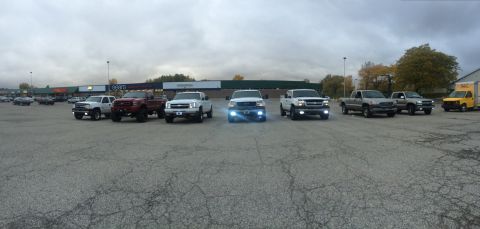 2006 Chevrolet Silverado 2500 - A group of Chevrolet Silverado trucks are parked in a lot under a cloudy sky.