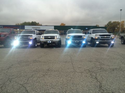 2006 Chevrolet Silverado 2500 - Several Chevrolet Silverado pickup trucks are parked in a lot under an overcast sky.