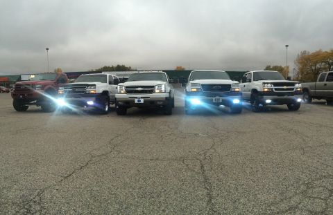 2006 Chevrolet Silverado 2500 - Multiple Chevrolet Silverado trucks are lined up in a parking lot under an overcast sky.
