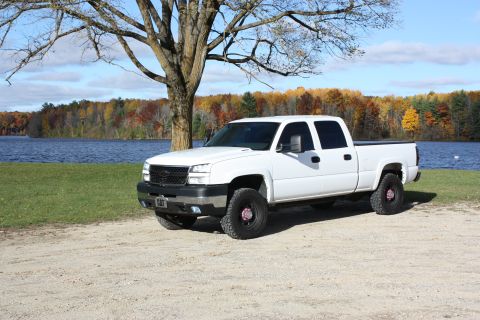 2006 Chevrolet Silverado 2500 - A white 2006 Chevrolet Silverado 2500 is parked near a lake during autumn.