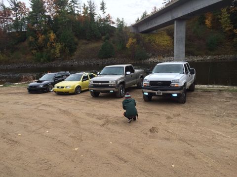 2006 Chevrolet Silverado 2500 - Several vehicles, including a 2006 Chevrolet Silverado 2500, are parked outdoors near a body of water.