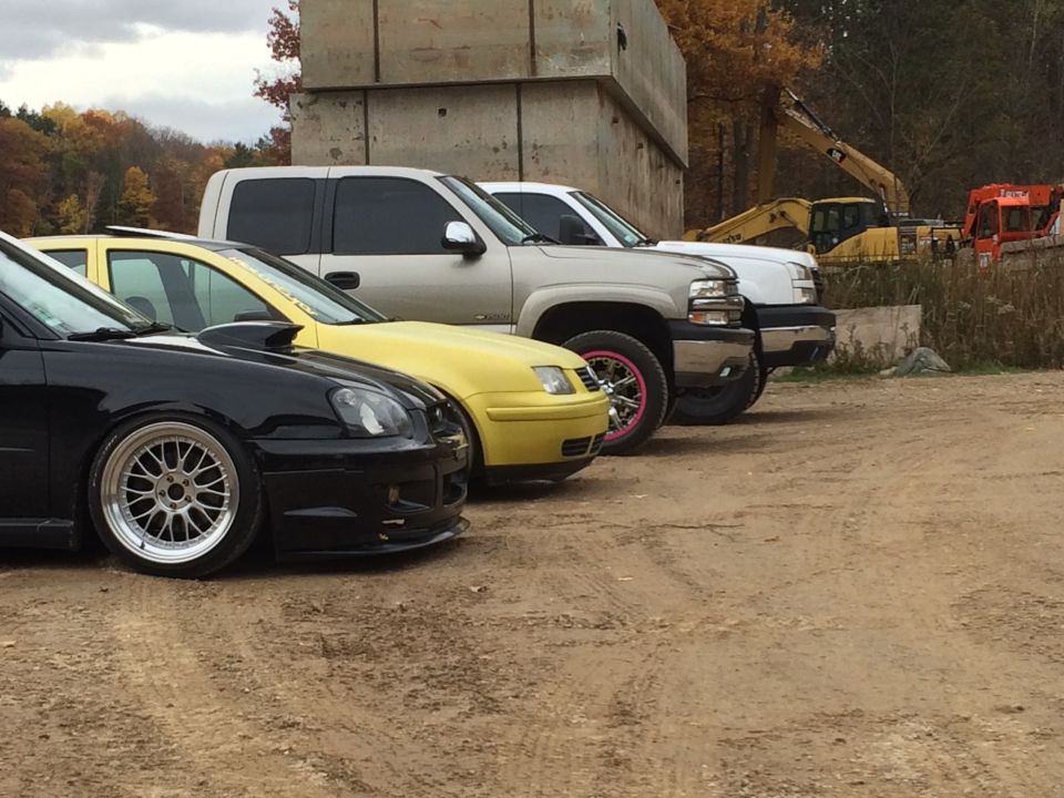 Black Subaru WRX, yellow Volkswagen Jetta, and a silver Chevrolet Silverado pickup truck parked side-by-side