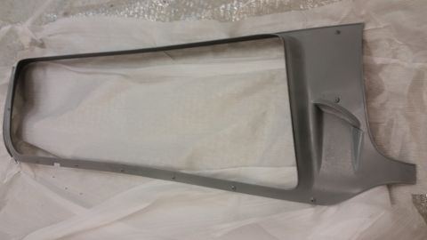 1987 Dodge 1500 - This is a gray metal part, likely a grille surround, lying on a white surface.