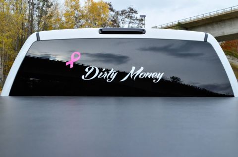 2006 Chevrolet Silverado 2500 - A truck's rear window displays a pink ribbon and the words 'Dirty Money' in white lettering.