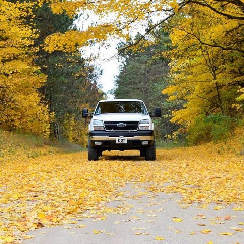 2006 Chevrolet Silverado 2500 - A 2006 Chevrolet Silverado 2500 is seen on a road during autumn, with fallen leaves covering the ground.