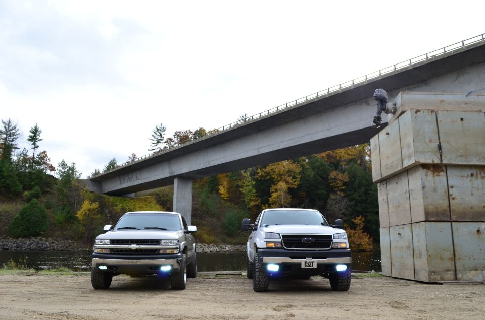 Front view of two 2006 Chevrolet Silverado 2500 trucks parked under a bridge